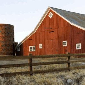 Preparing Your Farm for Fall: Equipment and Supply Checklist - pictured is fence with barn in the background